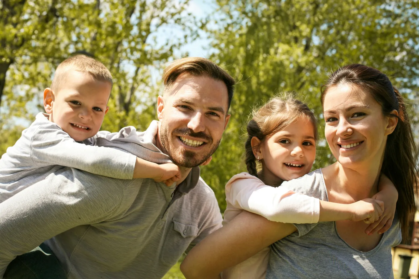 Parents smiling with their two young children outdoors